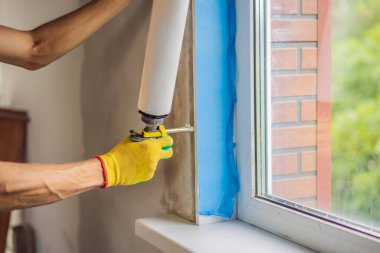 İnşaatçı veya tamirci pencerelerin onarımı veya kurulumu ile meşguldür