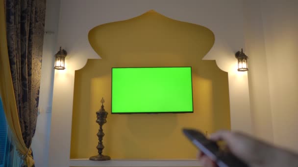 Pared con TV y pantalla verde al estilo de Oriente Medio y Norte de África. Mano con mando a distancia. Copa Árabe en Qatar — Vídeos de Stock