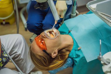 Dişçileri muayene eden bir kadın. Diş hekimliğinde diş tedavisi. Dişçide randevum var. Yaşam tarzı, gerçek hayat.