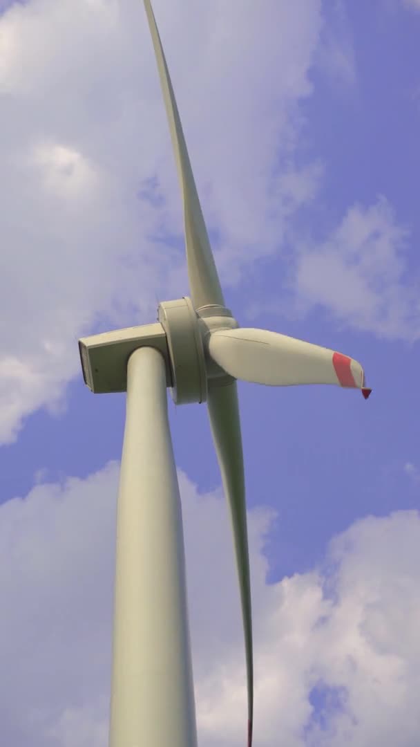 손에 총을 맞았어요. 뒤에 푸른 구름낀 하늘을 배경으로 한 풍력 터빈. 녹색 에너지에 대한 투자. 녹색 전기 개념 — 비디오