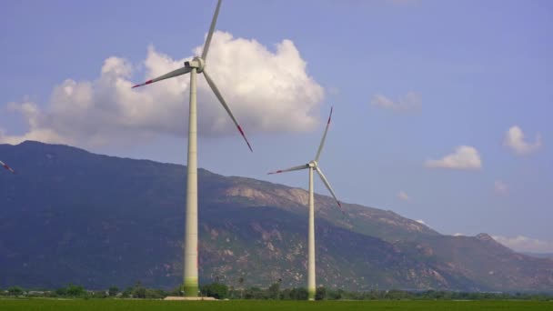手持ち撮影。風力発電所がたくさんある大きな緑。グリーンエネルギーへの投資。グリーン電力の概念 — ストック動画