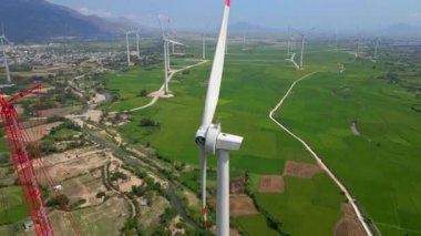 Hava görüntüsü. Bir sürü rüzgar santrali olan büyük yeşil bir dosya. Bir elektrik santrali yapım aşamasında. Yeşil enerjiye yatırım. Yeşil elektrik kavramı