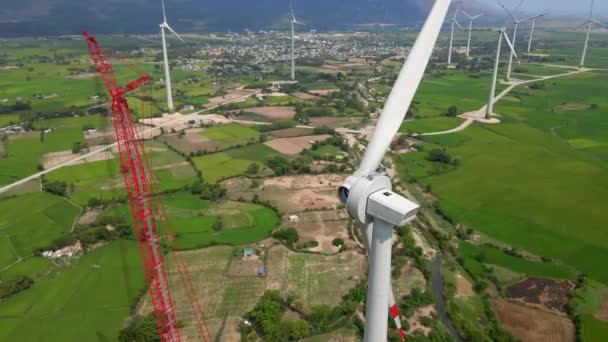 Letecký záběr. Velká zelená se spoustou větrných elektráren. Jedna elektrárna je ve výstavbě. Investice do zelené energie. Koncept zelené elektřiny — Stock video