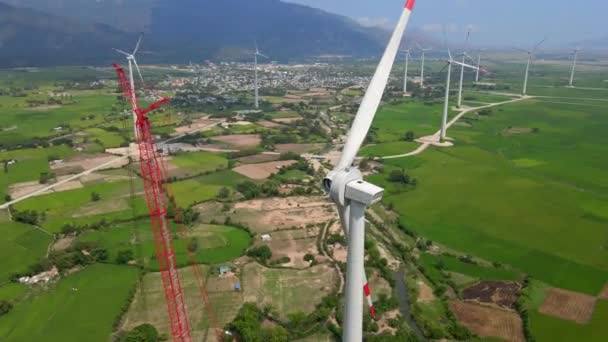 Letecký záběr. Velká zelená se spoustou větrných elektráren. Jedna elektrárna je ve výstavbě. Investice do zelené energie. Koncept zelené elektřiny — Stock video