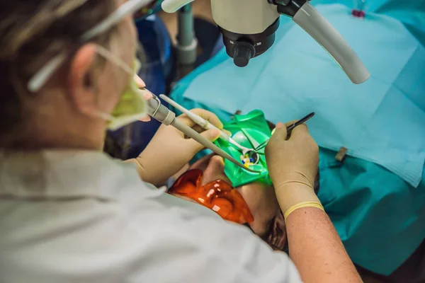 Tandheelkundige behandeling met een microscoop. Een man die tanden laat onderzoeken bij tandartsen. Afspraak bij de tandarts. lifestyle, het echte leven — Stockfoto