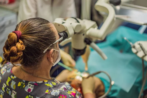 Tandheelkundige behandeling met een microscoop. Een vrouw die tanden laat onderzoeken bij tandartsen. Afspraak bij de tandarts. lifestyle, het echte leven — Stockfoto