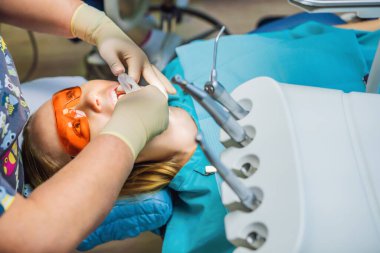 Dişçileri muayene eden bir kadın. Diş hekimliğinde diş tedavisi. Dişçide randevum var. Yaşam tarzı, gerçek hayat.