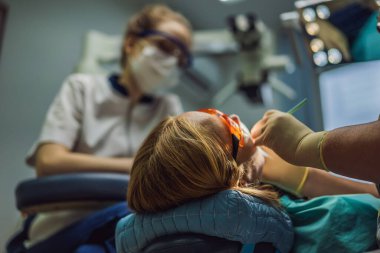 Dişçileri muayene eden bir kadın. Diş hekimliğinde diş tedavisi. Dişçide randevum var. Yaşam tarzı, gerçek hayat.