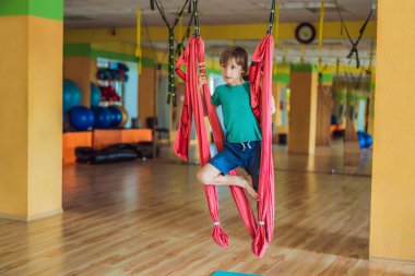Spor salonunda hava yogası yapan küçük bir çocuk. Yaşam tarzı. Çocuklar yoga konsepti