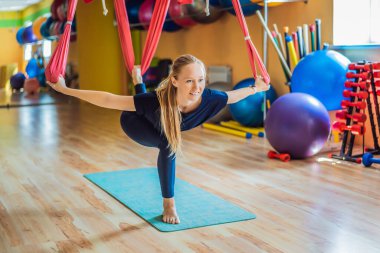Genç ve güzel bir kadın spor salonunda hava yogası yapıyor. Yaşam biçimi