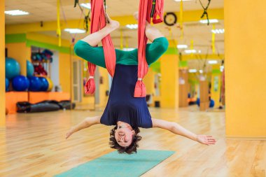 Yetişkin bir kadın stüdyoda hamakla anti-yerçekimi yogası yapıyor. Yaşam biçimi