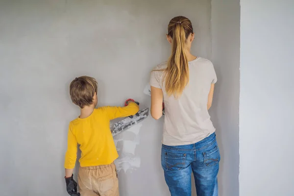 Kobieta Synem Robi Naprawy Domu Uczy Chłopca Tynkować Ściany Łopatką — Zdjęcie stockowe