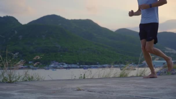 Повільний рух стрілянина молодого чоловіка, що біжить босоніж. Концепція запуску босоніж — стокове відео