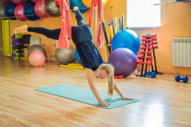 Genç ve güzel bir kadın spor salonunda hava yogası yapıyor. Yaşam biçimi