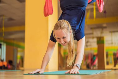 Genç ve güzel bir kadın spor salonunda hava yogası yapıyor. Yaşam biçimi