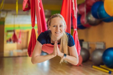 Genç ve güzel bir kadın spor salonunda hava yogası yapıyor. Yaşam biçimi