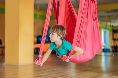 Spor salonunda hava yogası yapan küçük bir çocuk. Yaşam tarzı. Çocuklar yoga konsepti