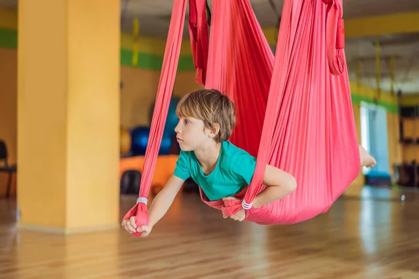 小男孩在体育馆练习空中瑜伽.生活方式。儿童瑜伽概念 — 图库照片