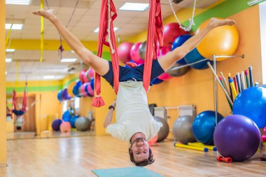 Spor salonunda hava yogası yapan genç bir adam. Yaşam biçimi