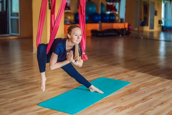 Giovane bella donna che pratica yoga aereo in palestra. Stile di vita — Foto Stock