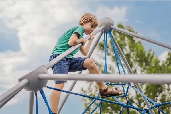 Ung pojke på klättring rep i lekplats — Stockfoto