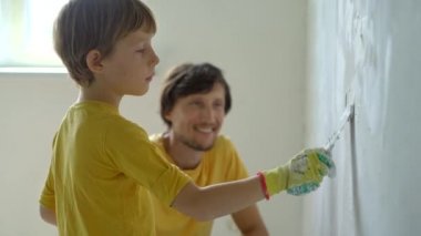Genç bir adam ve oğlu evlerinde duvarları yeniliyorlar. Duvara macun sürüyorlar. Kendin tadilat yap. Çocuklara kendi başlarına nasıl tamir edeceklerini öğretmek.