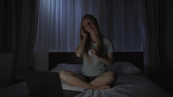 夜の女性は瞑想をオンにし、ベッドに行く前にリラックスするために彼女のコンピュータ上のアプリケーションを緩和します。ストレス対策アプリ。健康的なライフスタイル。新常態 — ストック動画