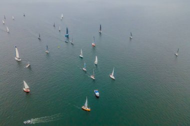 Uçan kuşlar, turkuaz deniz suyunda yelkenlinin drone 'u tarafından çekilmiş bir fotoğrafı.