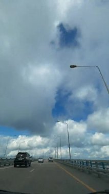 Dikey video. Rusya 'nın Vladivostok kentindeki Russky Köprüsü' nden geçen bir aracın aşırı hızlanması.