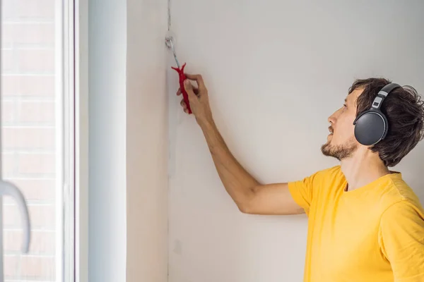 Jeden malarz maluje i gruntuje ścianę wałkiem malarskim. DIY — Zdjęcie stockowe