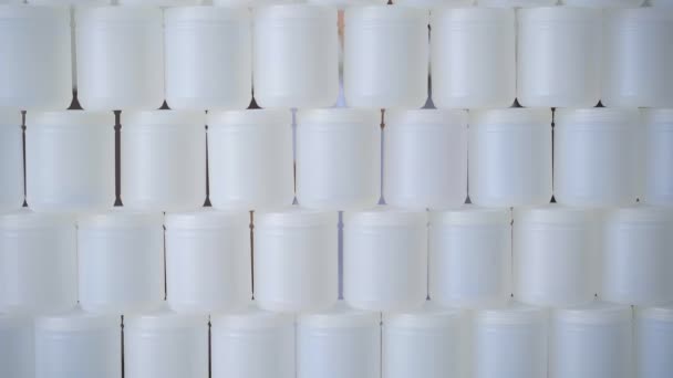 Um homem com uma paragem de letras na mão parte uma parede feita de latas de plástico. Parem a poluição plástica. Reduzir plásticos de uso único. Vídeo em câmara lenta — Vídeo de Stock