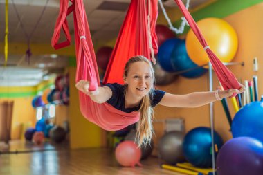 Genç ve güzel bir kadın spor salonunda hava yogası yapıyor. Yaşam biçimi
