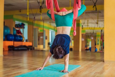 Yetişkin bir kadın stüdyoda hamakla anti-yerçekimi yogası yapıyor. Yaşam biçimi