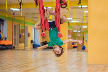 Spor salonunda hava yogası yapan küçük bir çocuk. Yaşam tarzı. Çocuklar yoga konsepti