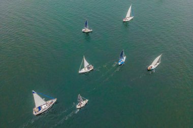 Uçan kuşlar, turkuaz deniz suyunda yelkenlinin drone 'u tarafından çekilmiş bir fotoğrafı.