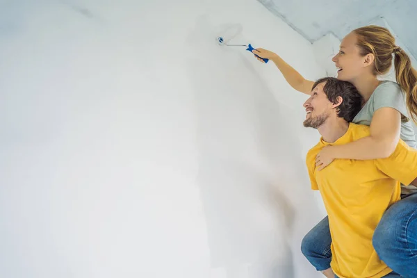 Yeni ev boyama duvarında tadilat yapan çift. — Stok fotoğraf