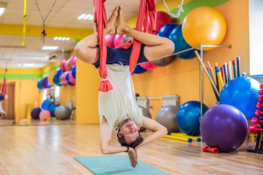 Spor salonunda hava yogası yapan genç bir adam. Yaşam biçimi
