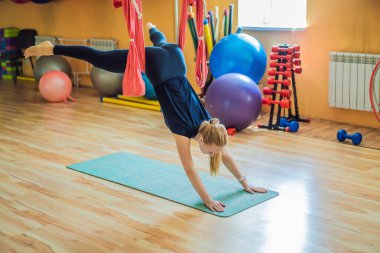 Genç ve güzel bir kadın spor salonunda hava yogası yapıyor. Yaşam biçimi