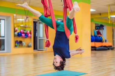 Yetişkin bir kadın stüdyoda hamakla anti-yerçekimi yogası yapıyor. Yaşam biçimi