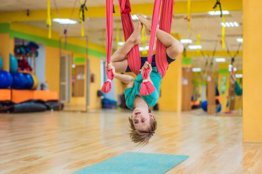 Spor salonunda hava yogası yapan küçük bir çocuk. Yaşam tarzı. Çocuklar yoga konsepti