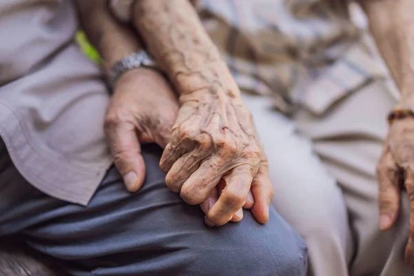 Ouderen houden elkaars hand vast met liefde. Hand van een oudere vrouw die de hand van een oudere man vasthoudt — Stockfoto