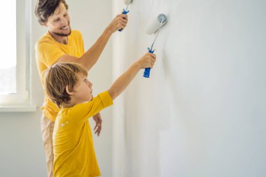 Baba ve oğul evlerinde duvar boyuyor. Taşınırken yapıyorlar.