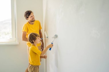 Baba ve oğul evlerinde duvar boyuyor. Taşınırken yapıyorlar.
