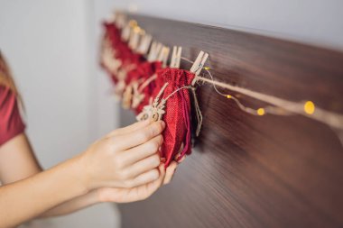 Noel takvimi hazırlayan bir kadın. İpteki keseler.