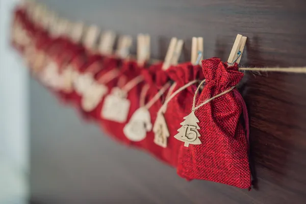 Calendario dell'avvento borse rosse su una corda appendono su un letto di bambini — Foto Stock