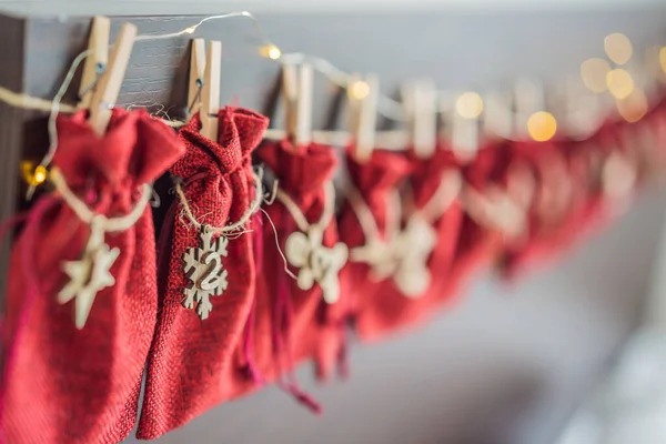 Calendario de Adviento bolsas rojas en una cuerda cuelgan de una cama infantil — Foto de Stock