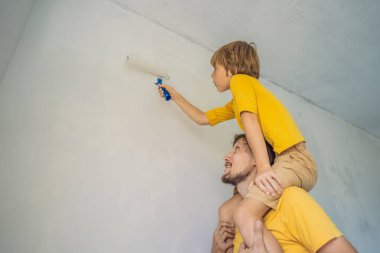 Baba ve oğul evlerinde duvar boyuyor. Taşınırken yapıyorlar.