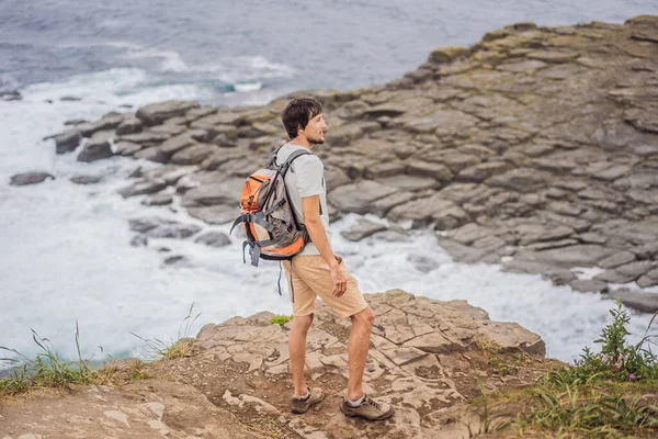 Turista masculino en el fondo de hermosas rocas y el mar. Concepto de senderismo. Capa de Tobizin. Vladivostok, isla Russky. Mar de Japón. Primorye. Primorsky krai. Naturaleza de Rusia. Turismo y viajes en —  Fotos de Stock