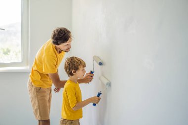 Baba ve oğul evlerinde duvar boyuyor. Taşınırken yapıyorlar.