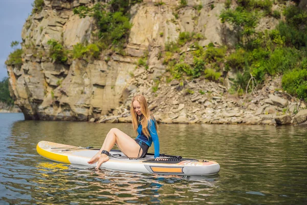 Young women Having Fun Stand Up Paddling in the sea. SUP. Red hair girl Training on Paddle Board near the rocks — Stock Photo, Image